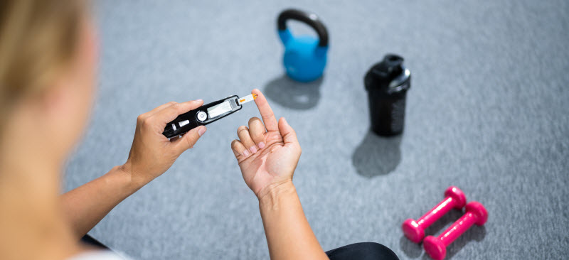 Woman checking her blood sugar while working out