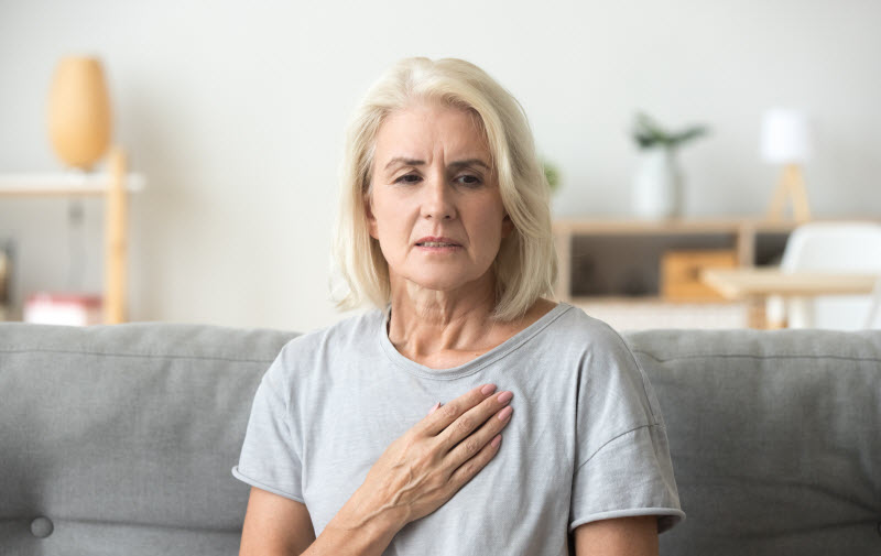 Woman touching her chest feeling a pain